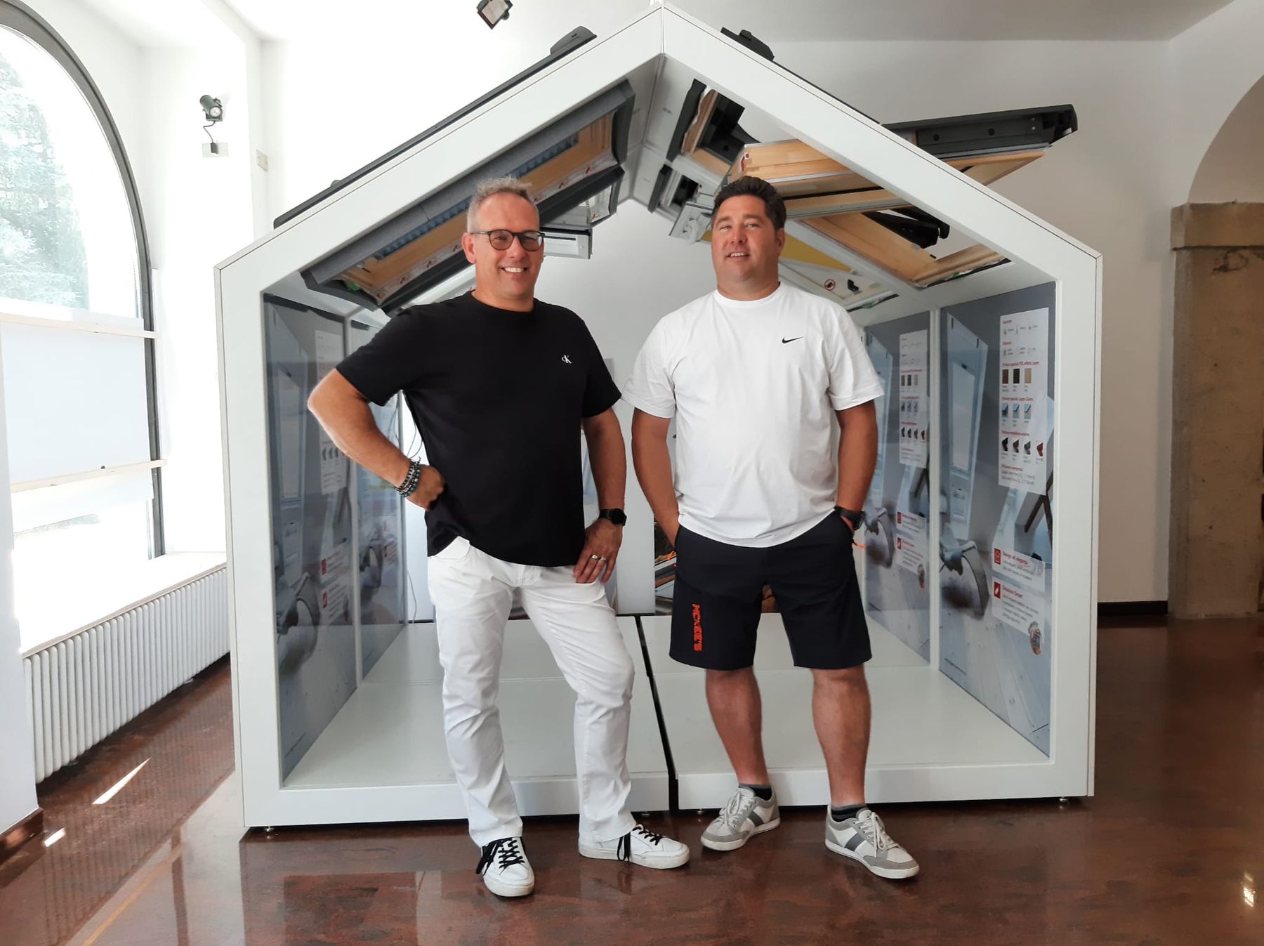 I fratelli Faes nello showroom, accanto alla sezione di tetto in scala reale con finestre ROTO