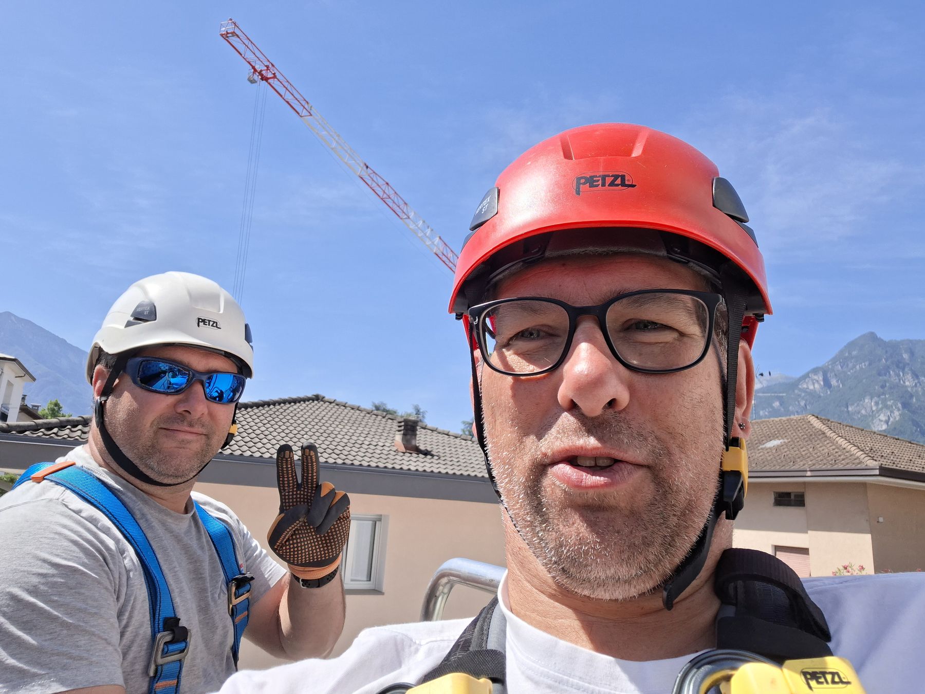 I fratelli Faes sul tetto durante un cantiere, un saluto alla macchina fotografica