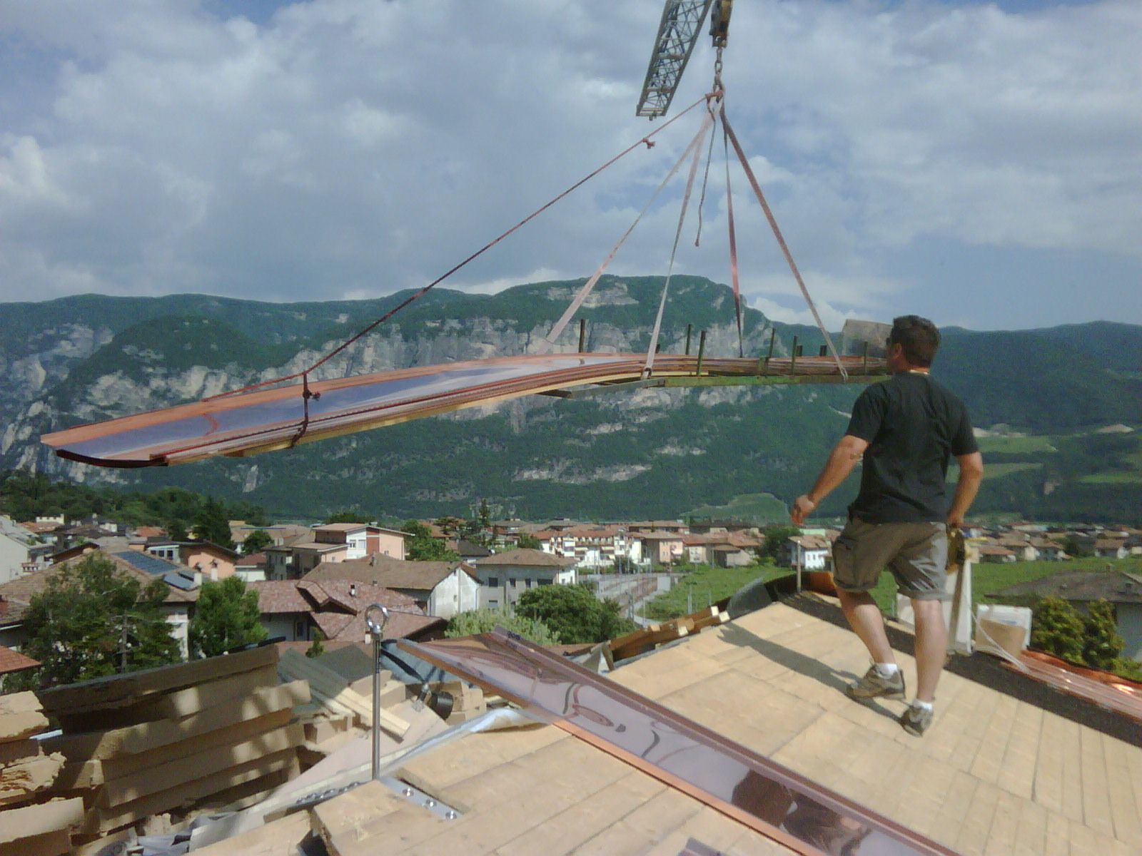 Posizionamento dei materiali in quota con la gru su un cantiere di Lattonerie Faes